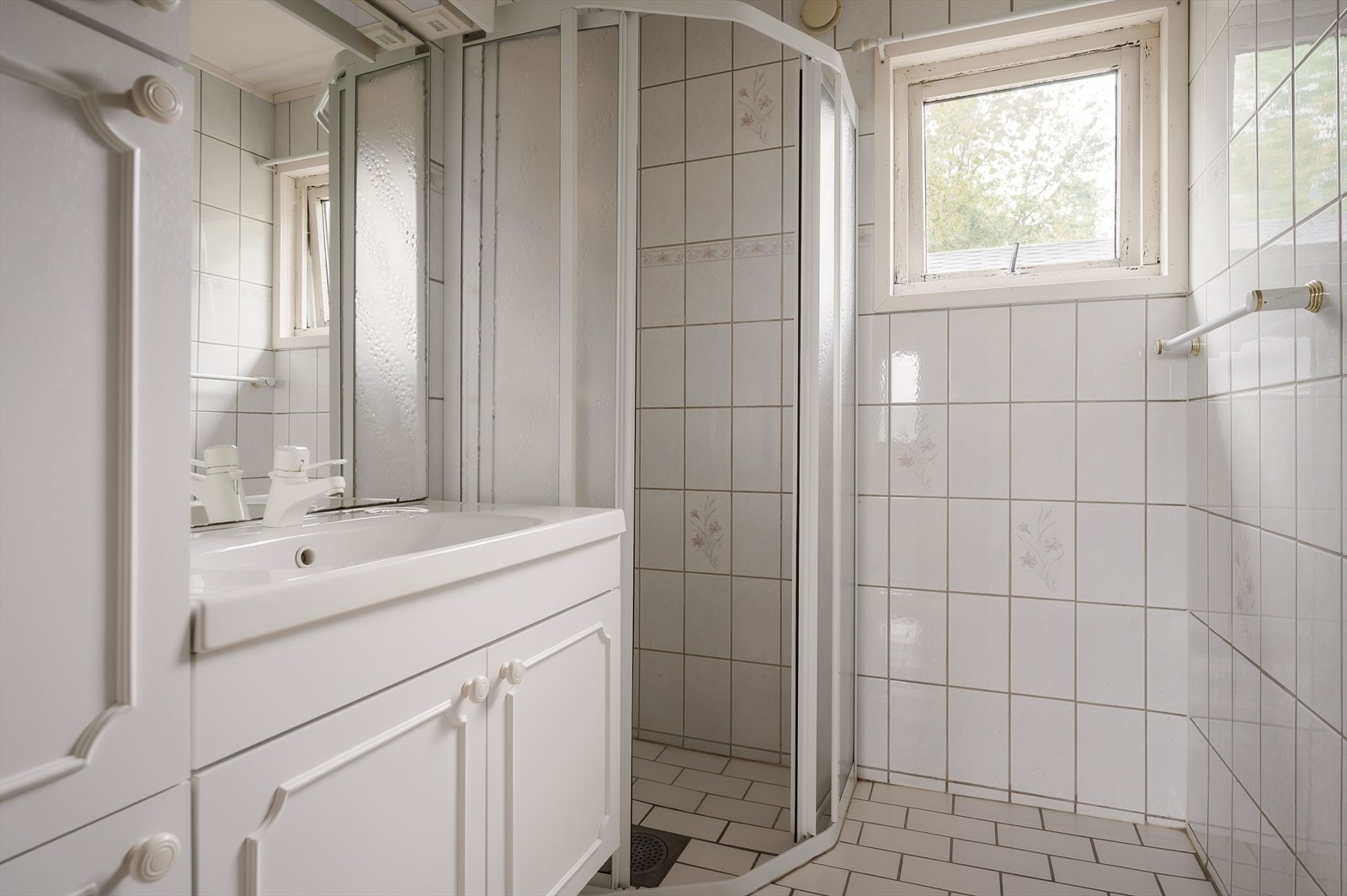Badet i første etasje har flislagte overflater, himlingsplater og elektrisk gulvvarme, med dusjvegger og ventilasjon. Galleribilde