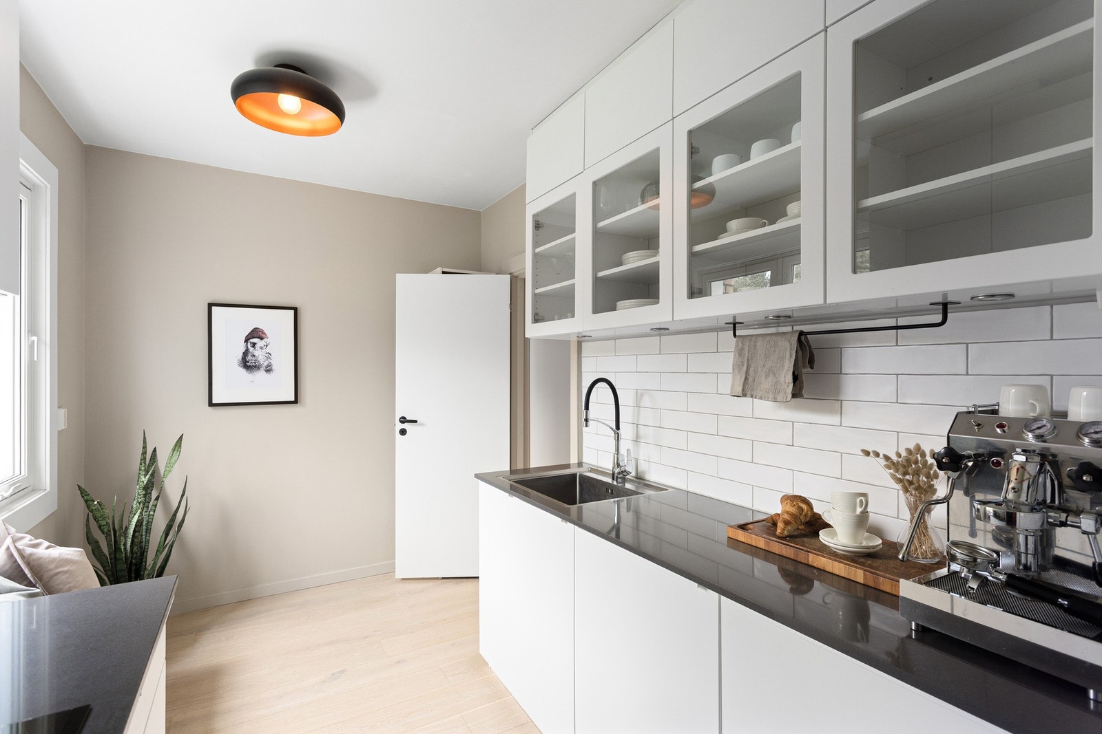Det er kjøkkeninnredning med slette fronter og benkeplate av stein, samt oppvaskkum. Galleribilde