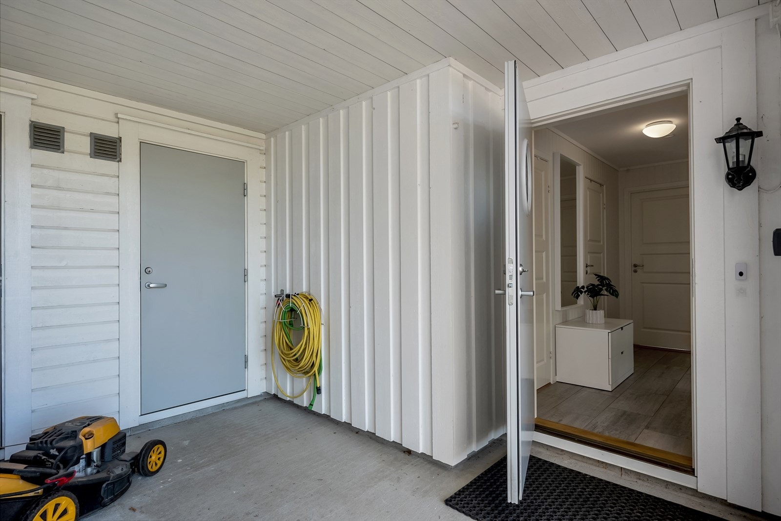 Overbygget inngangsparti gir en praktisk overgang til boligen. Galleribilde