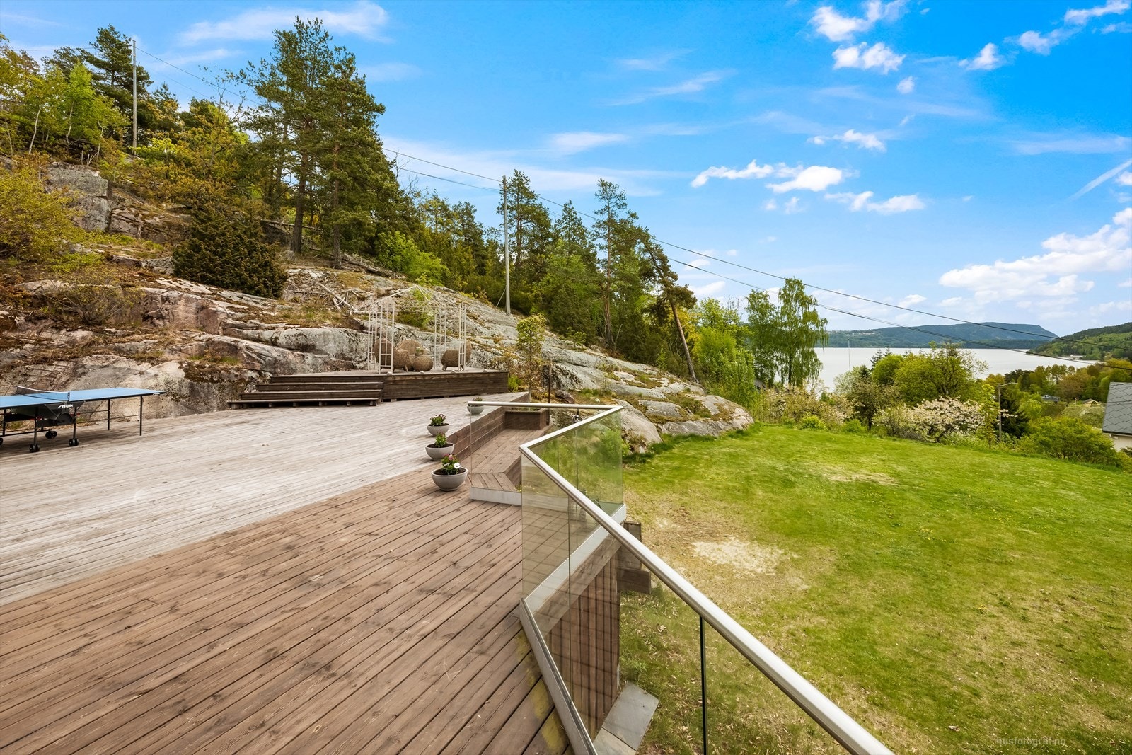 Den store terrassen i trekonstruksjon strekker seg rundt deler av huset og gir rikelig med uteplass. Galleribilde