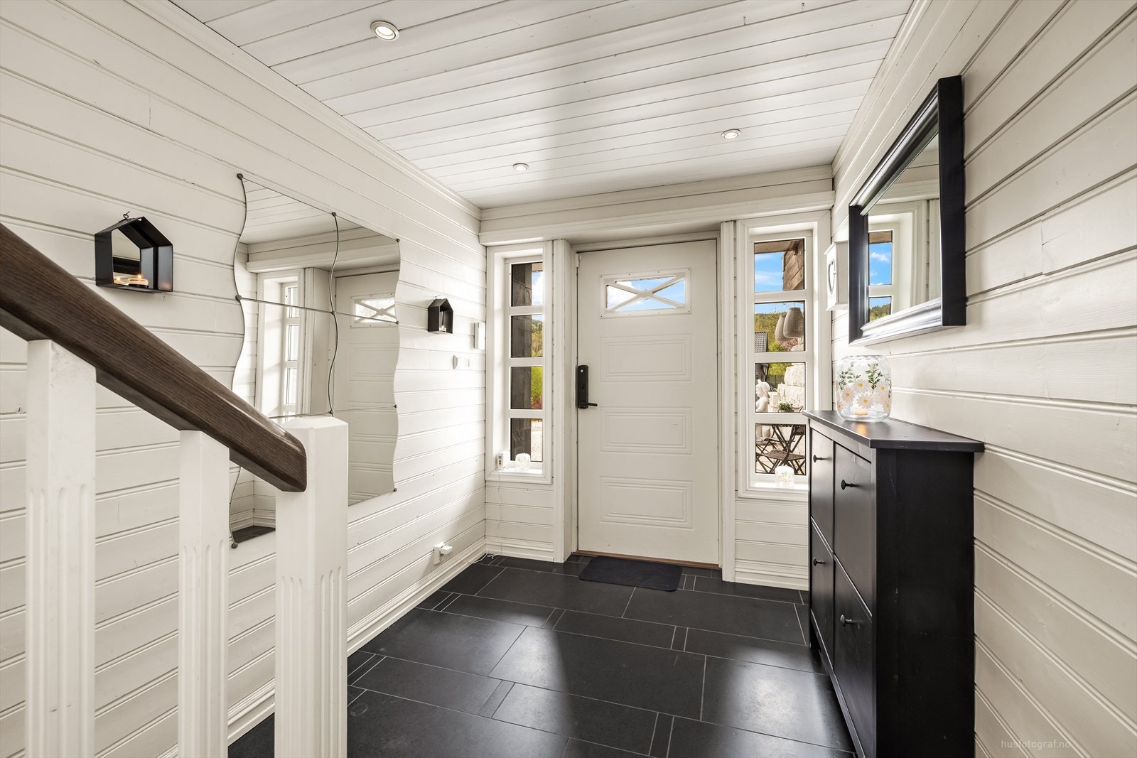 Hallen i underetasjen ønsker velkommen med en malt tretrapp som leder videre opp i boligen. Galleribilde