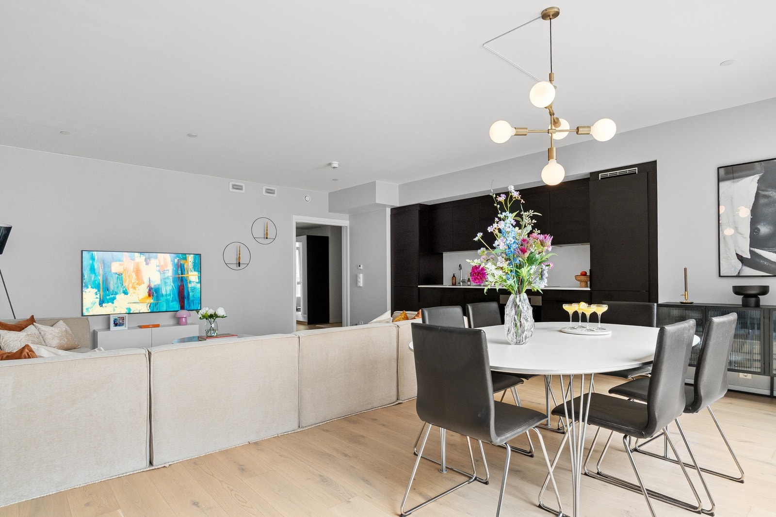 Innredningen har glatte, folierte fronter og laminat benkeplate med nedfelt kum i rustfritt stål, og det er belysning via downlights under overskap. Galleribilde