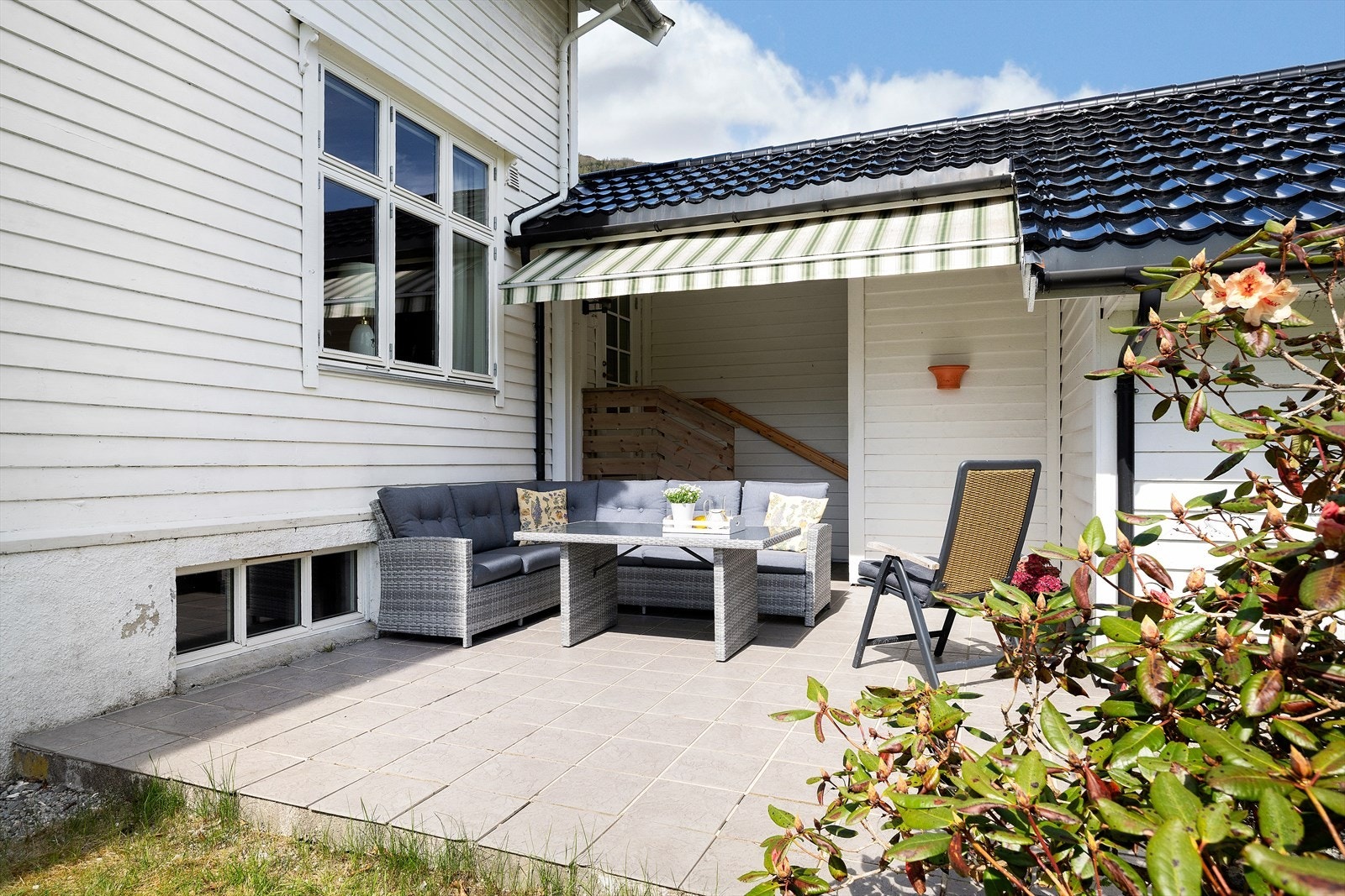 Lun og skjermet uteplass med flislagt betongterrasse. Galleribilde