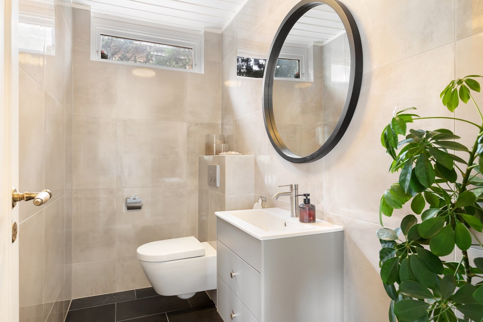 Pent toalettrom med gulvvarme. Rommet er utstyrt med naturlig avtrekk, veggmontert wc og servantskap med ettgreps blandebatteri fra Grohe. Galleribilde