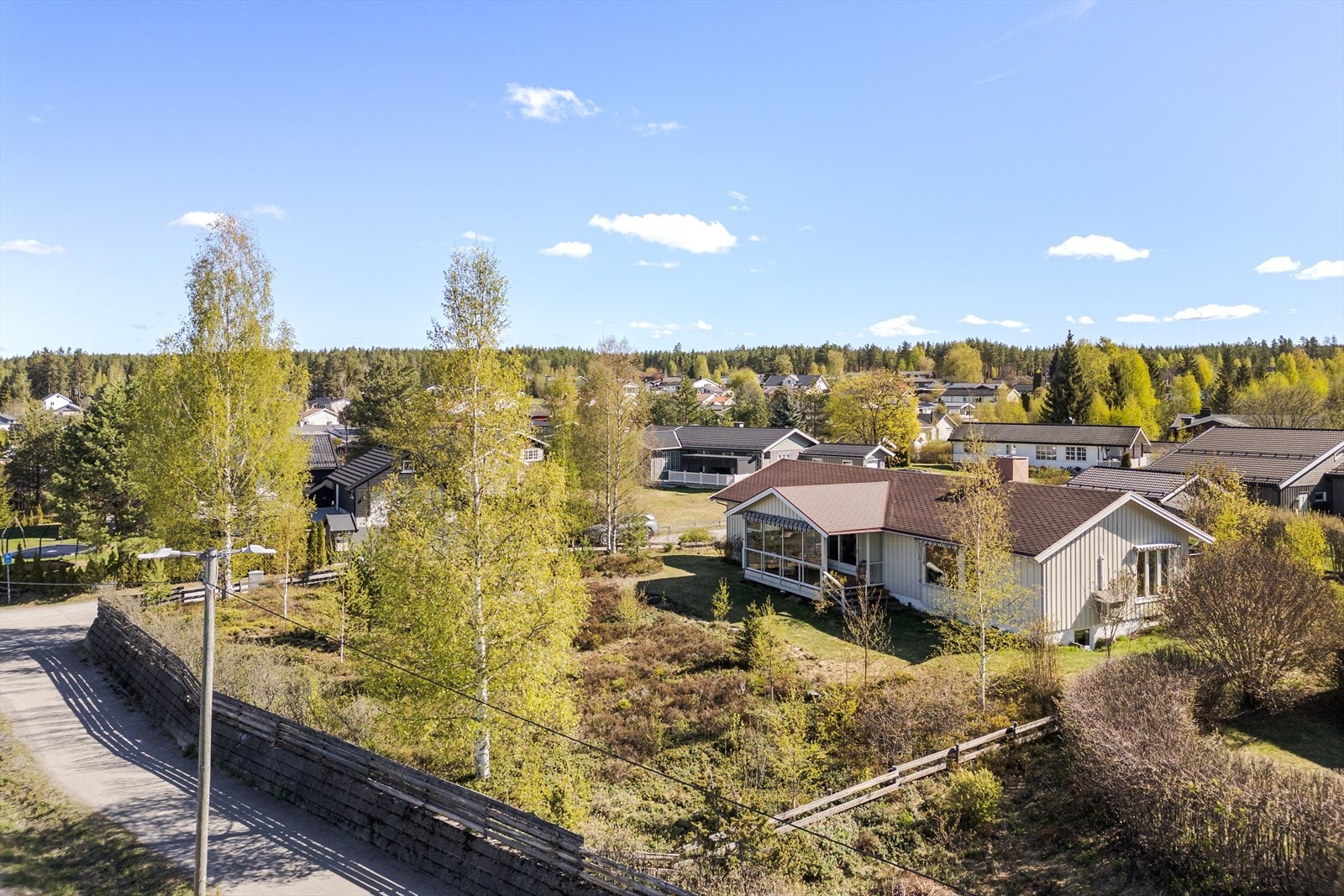 Ganske flat tomt delvis innhegnet med gjerde. Hageanlegg opparbeidet med plen og variert beplantning. Dels naturtomt. Galleribilde