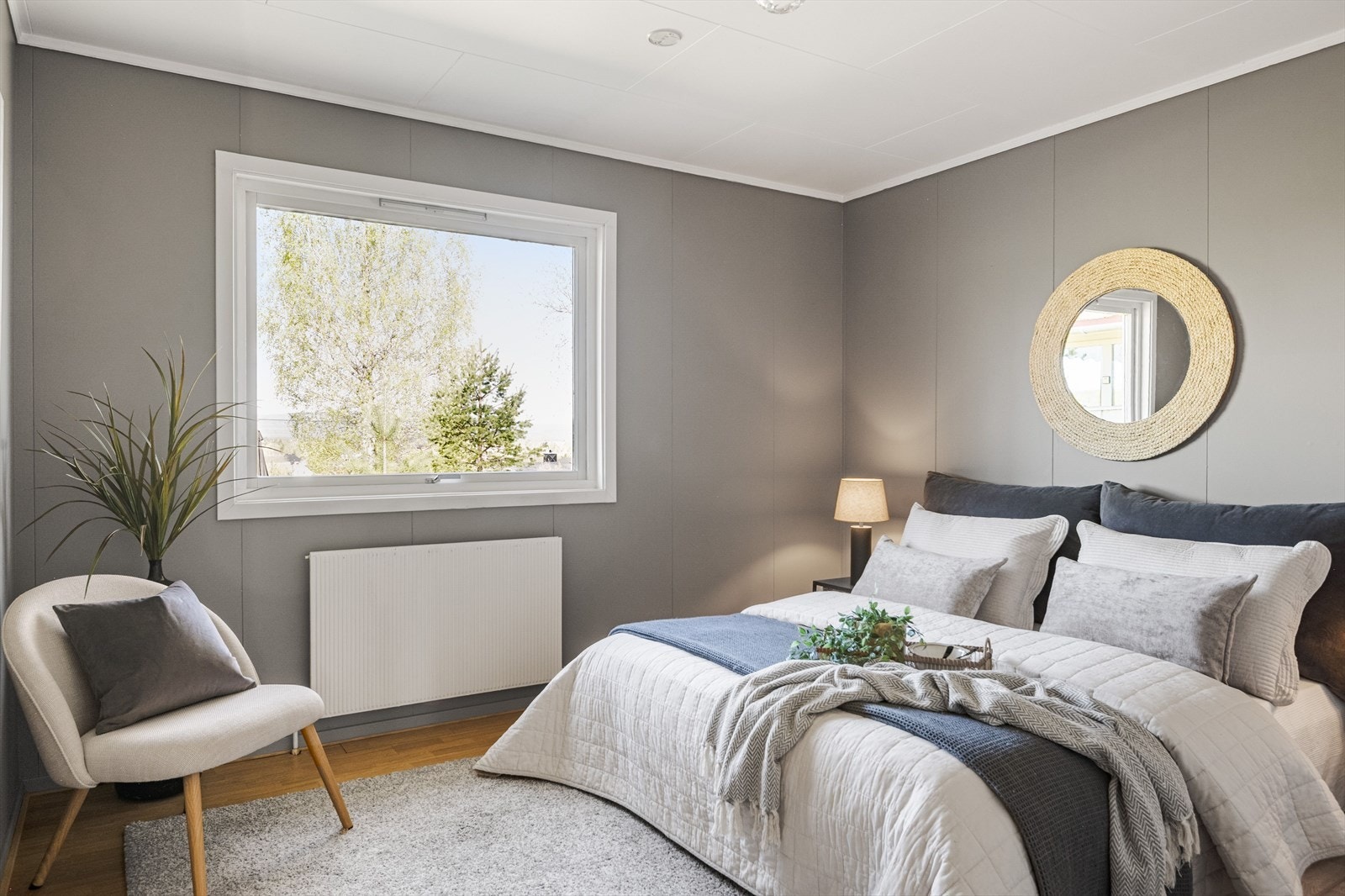 Lyst og pent hovedsoverom med parkett på gulv og nymalte plater på veggene. Galleribilde