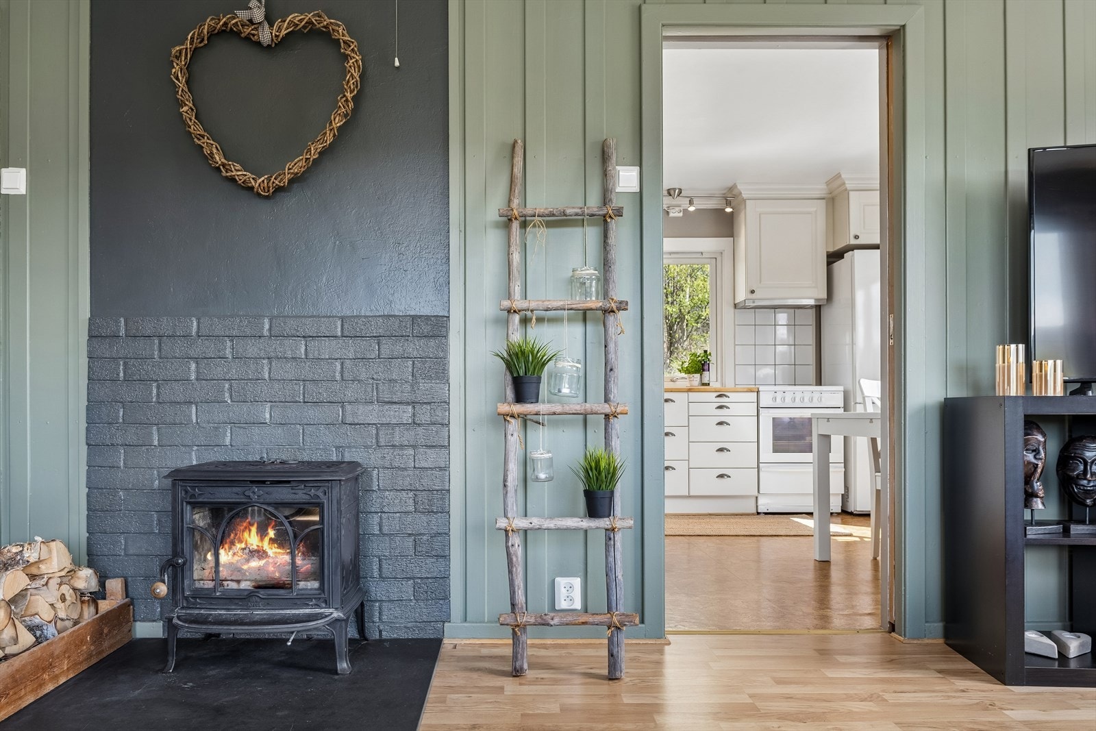Stuen har vegger med malt trepanel og laminat på gulvet. Galleribilde
