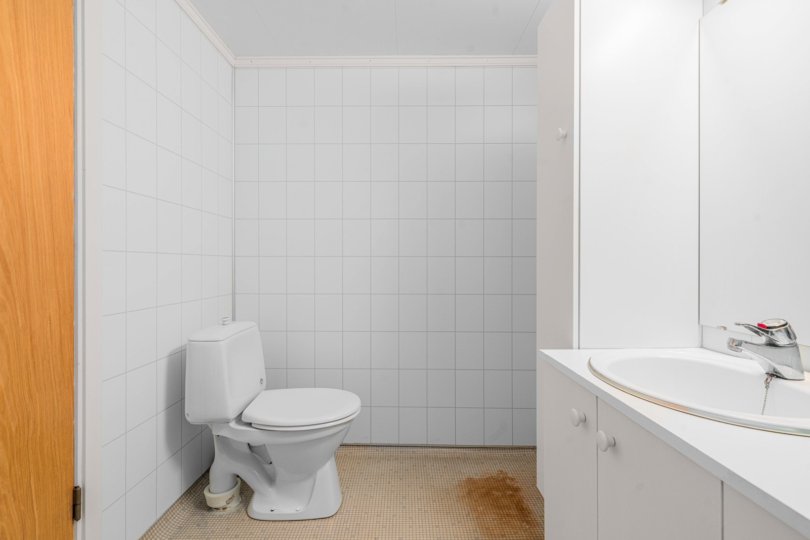 Badet er innredet med toalett og servant med underskap. Galleribilde