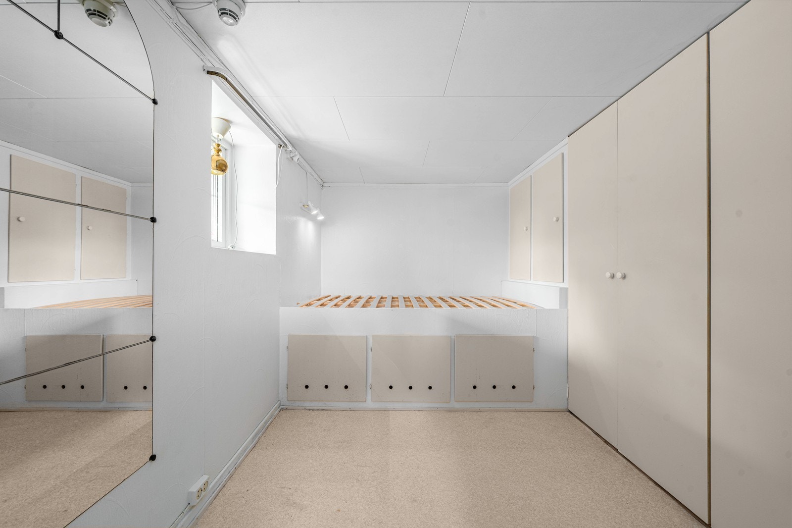 Innredet rom i kjelleren med smart, plassbygd sengeløsning og garderobeskap. Galleribilde