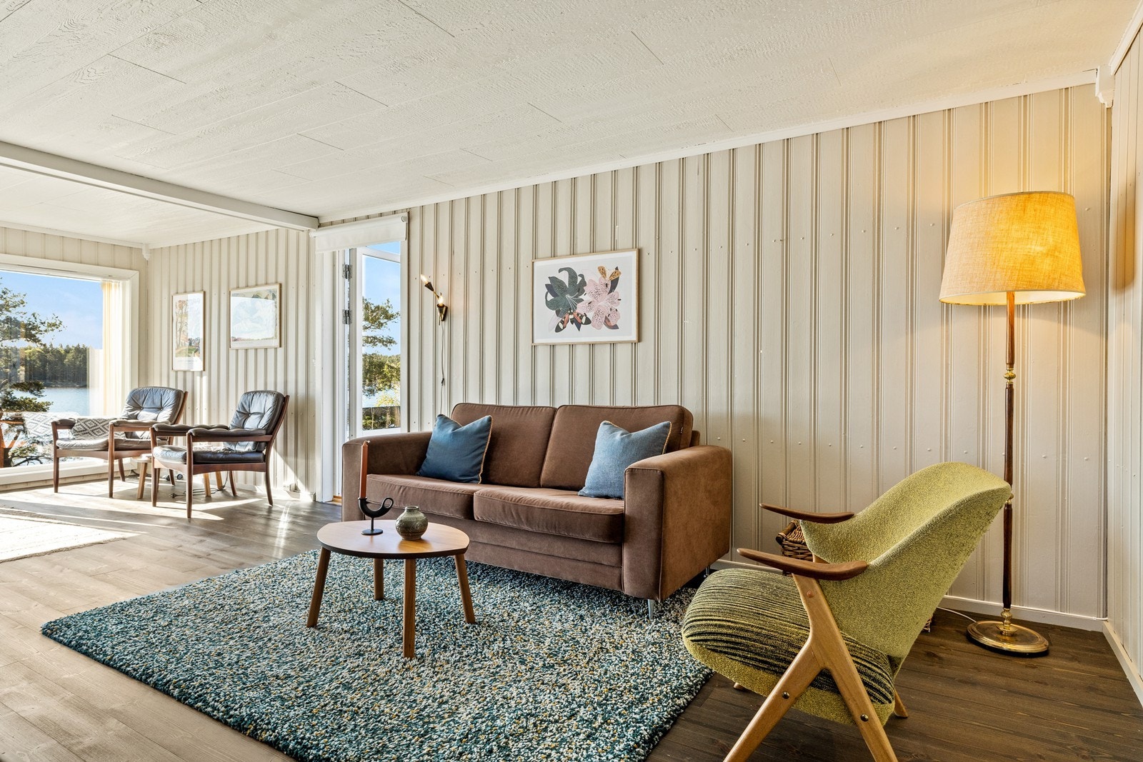 Gjennomgående heltre gulv og malte panelvegger skaper en helhetlig stil i boligen. Galleribilde