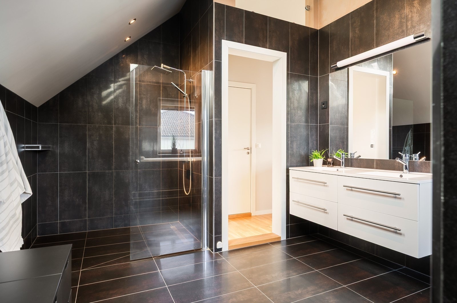 Badet har innredning med dobbel servant og en romslig dusjnisje med veggmontert dusjbatteri med regnfall. Galleribilde