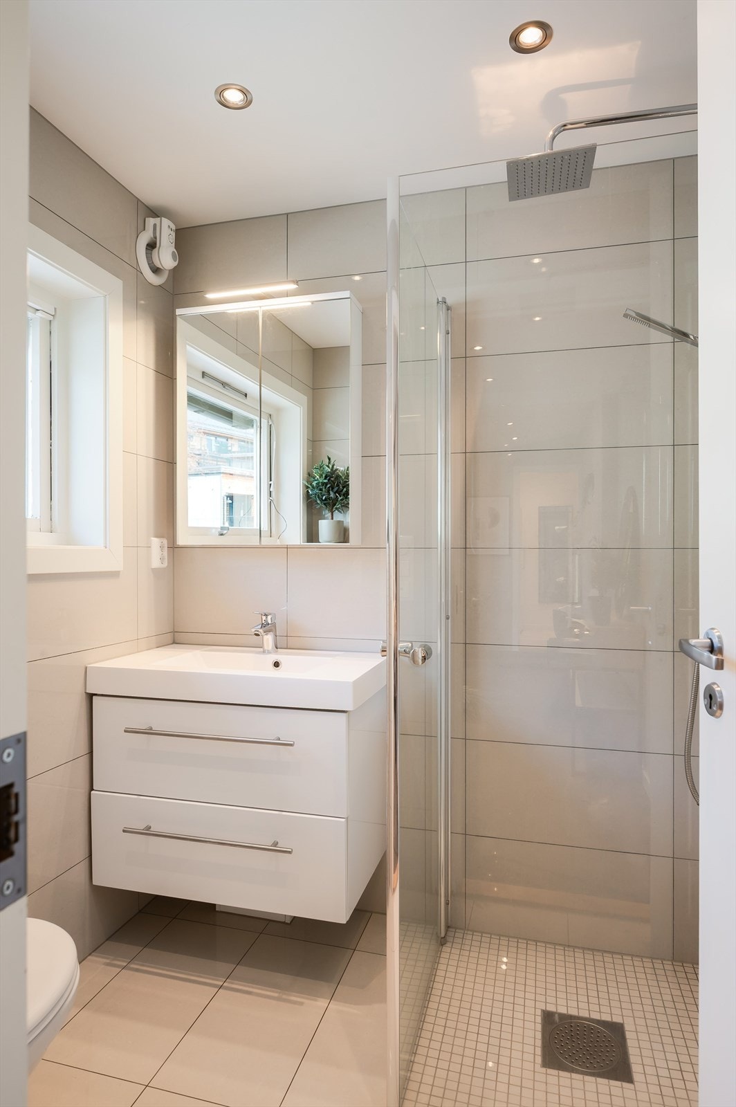 Praktisk flislagt bad i tilknytning til entréen med varmekabler i gulvet. Badet er fullverdig med toalett, baderomsinnredning og dusj. Galleribilde