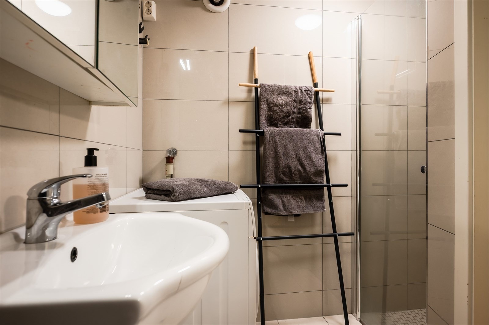 Flislagt bad med varme i gulvet. Badet har toalett, servant, dusjnisje med glassdør og opplegg for vaskemaskin. Galleribilde