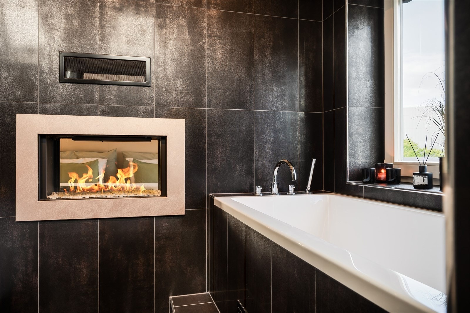 I veggen mellom badet og hovedsoverommet er det en gasspeis som kan ses fra begge sider. Galleribilde