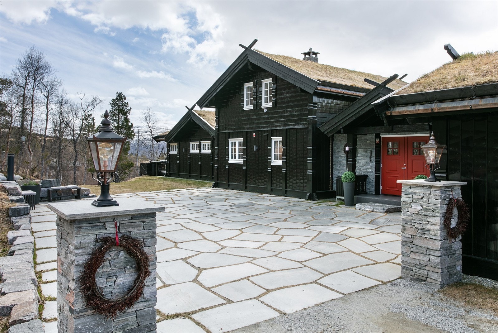 Portstolper i naturstein rammer inn innkjørselen til eiendommen. Galleribilde