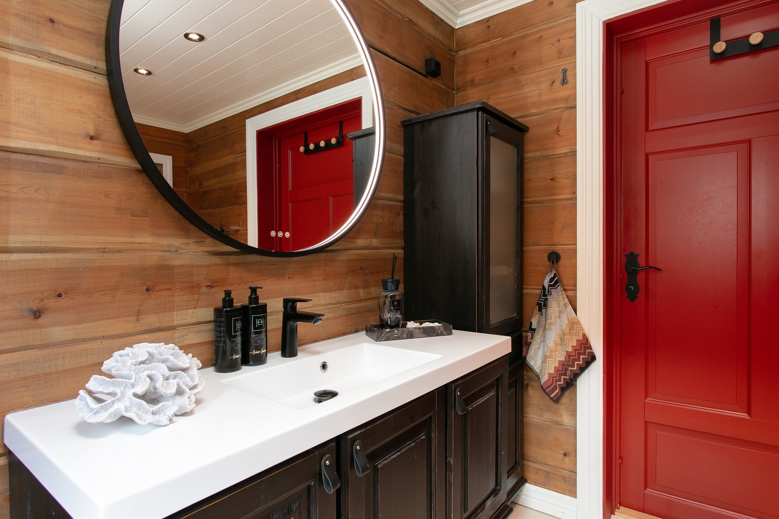 Detaljer fra badet i første etasje, med servantinnredning og speil med integrert belysning. Galleribilde