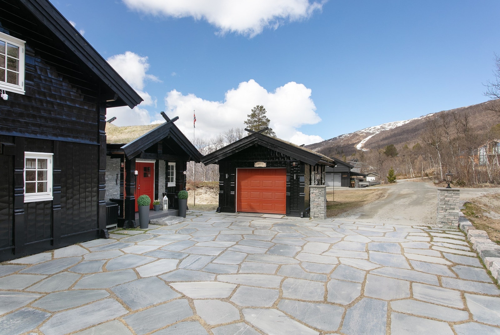 Den store, opparbeidede gårdsplassen gir god plass til parkering for flere biler. Galleribilde