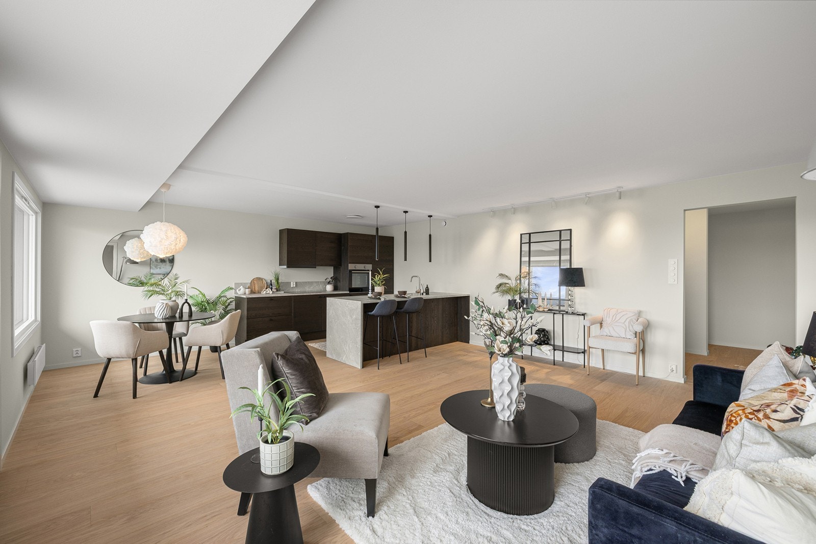 Lys og innbydende stue med åpen løsning mot kjøkken og spiseplass, som skaper en sosial og luftig atmosfære. Galleribilde