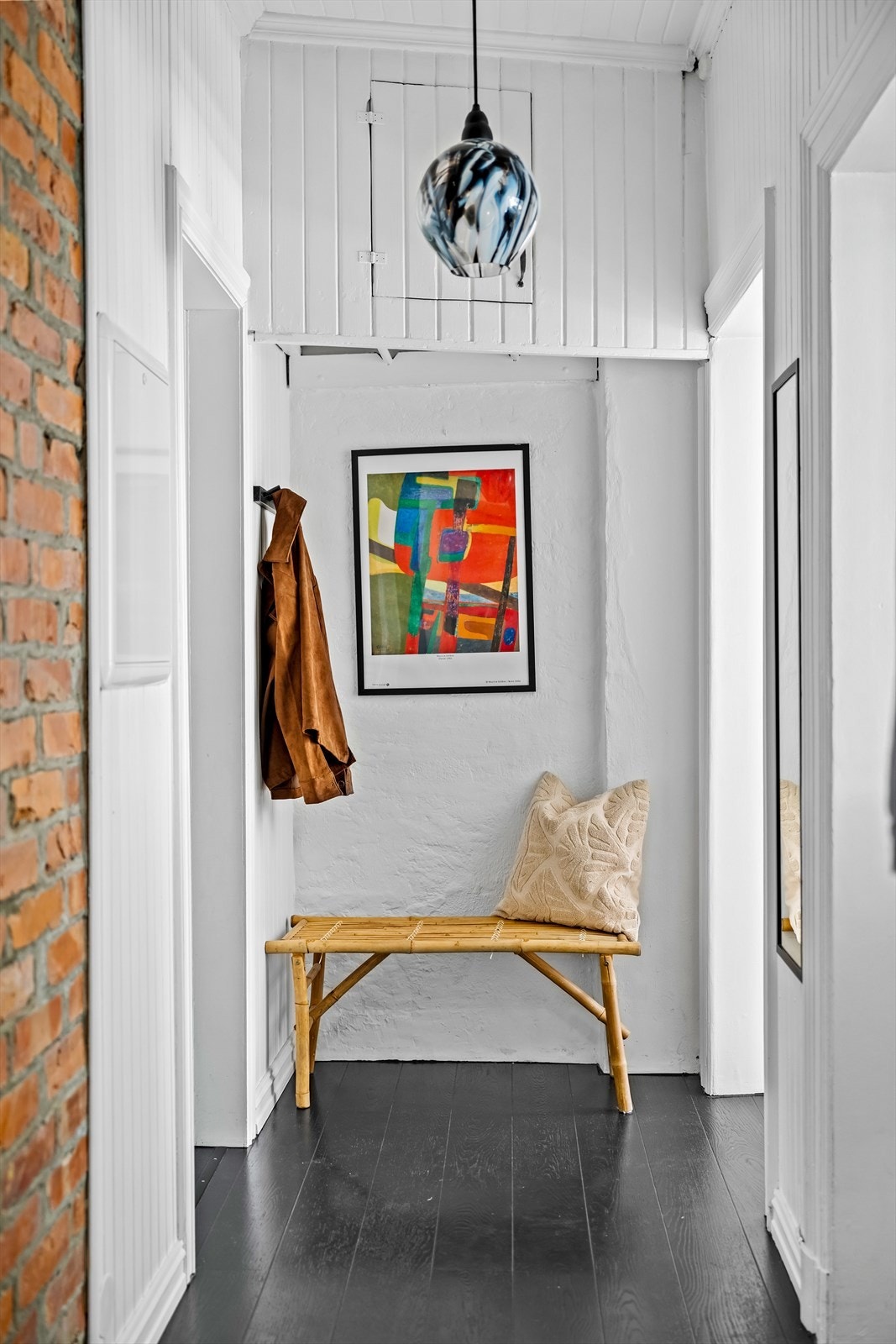 I entréen er det plass til å henge fra seg yttertøy og sette fra seg sko. En teglsteinsvegg, sammen med det malte trepanelet på øvrige vegger, gir et svært godt førsteinntrykk. Galleribilde