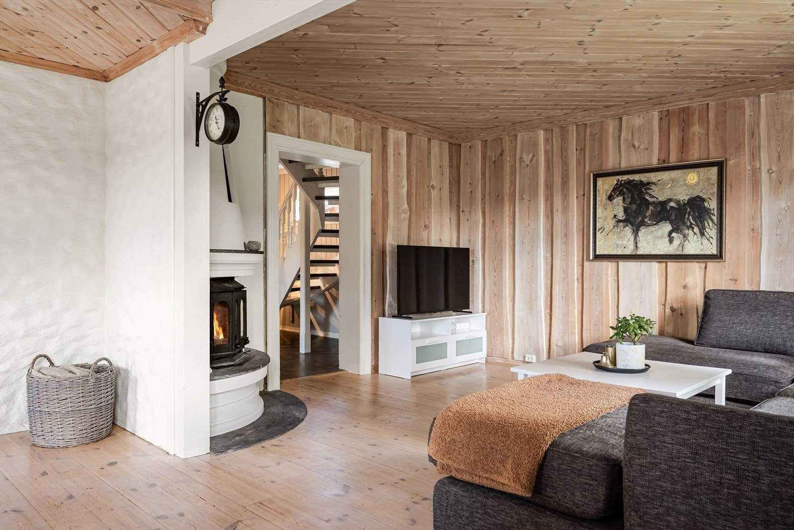 Stuen har trepanel på veggene og tregulv som gjør det lunt. Galleribilde