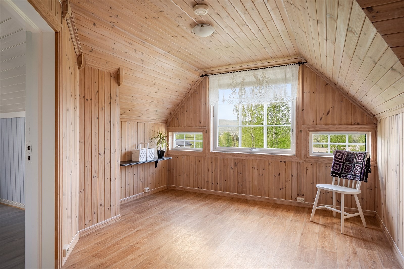 Loftstue med trepanel og laminatgulv. Galleribilde