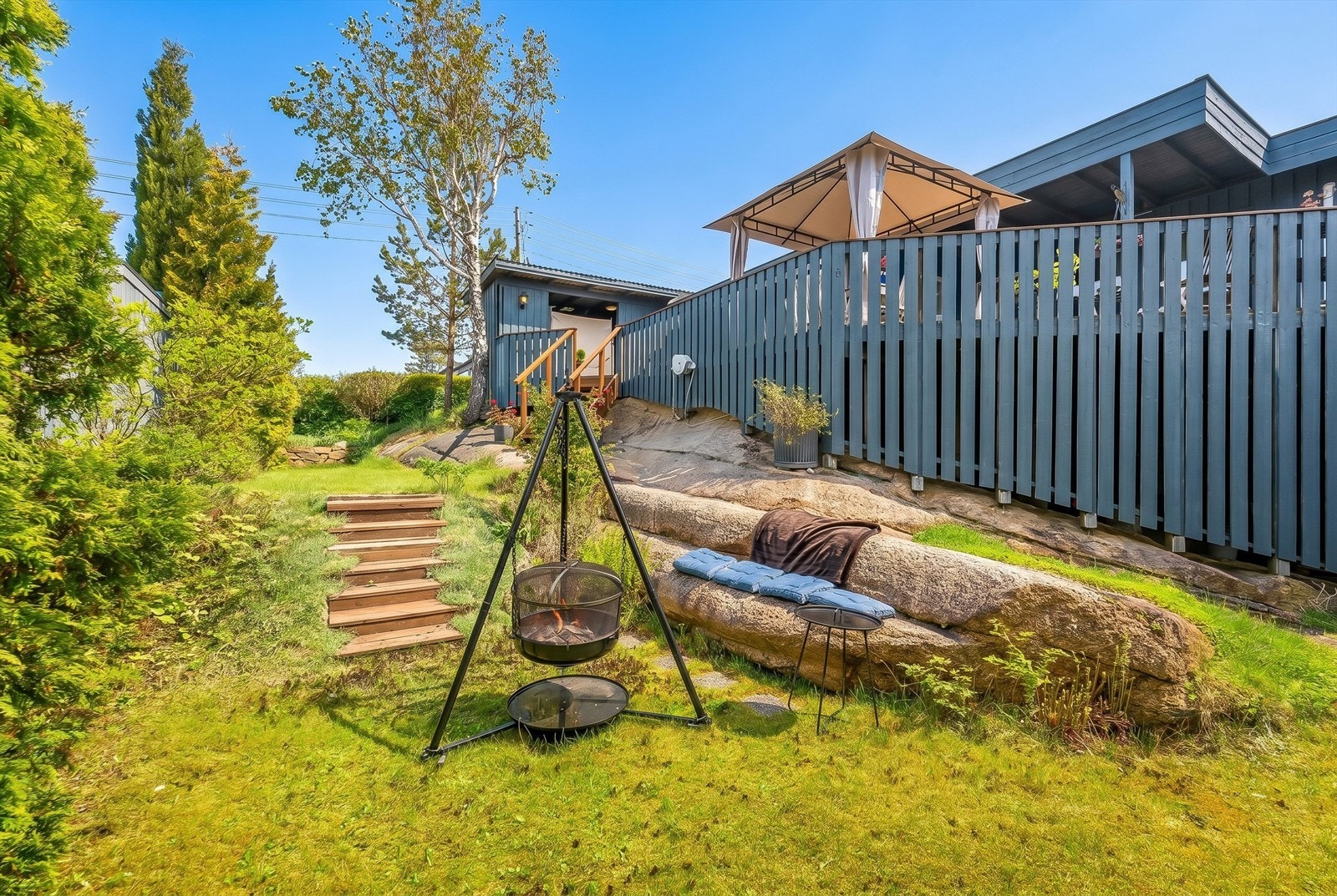 Den usjenerte hagen har en fin kombinasjon av plen og synlig fjell, som gir en sjarmerende ramme rundt uteplassen. Galleribilde