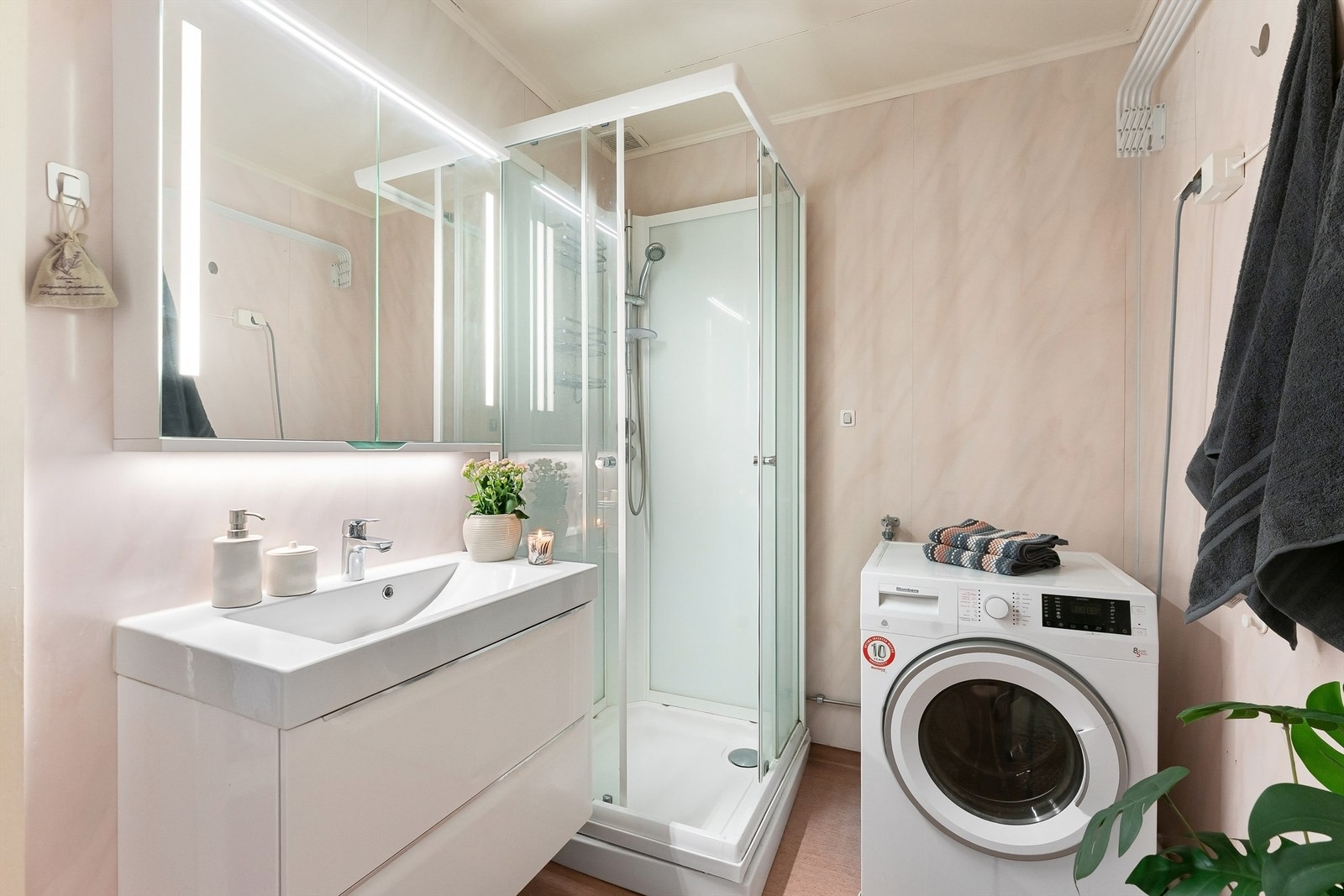 Badet har dusjkabinett, servantinnredning fra 2018 og opplegg for vaskemaskin. Galleribilde