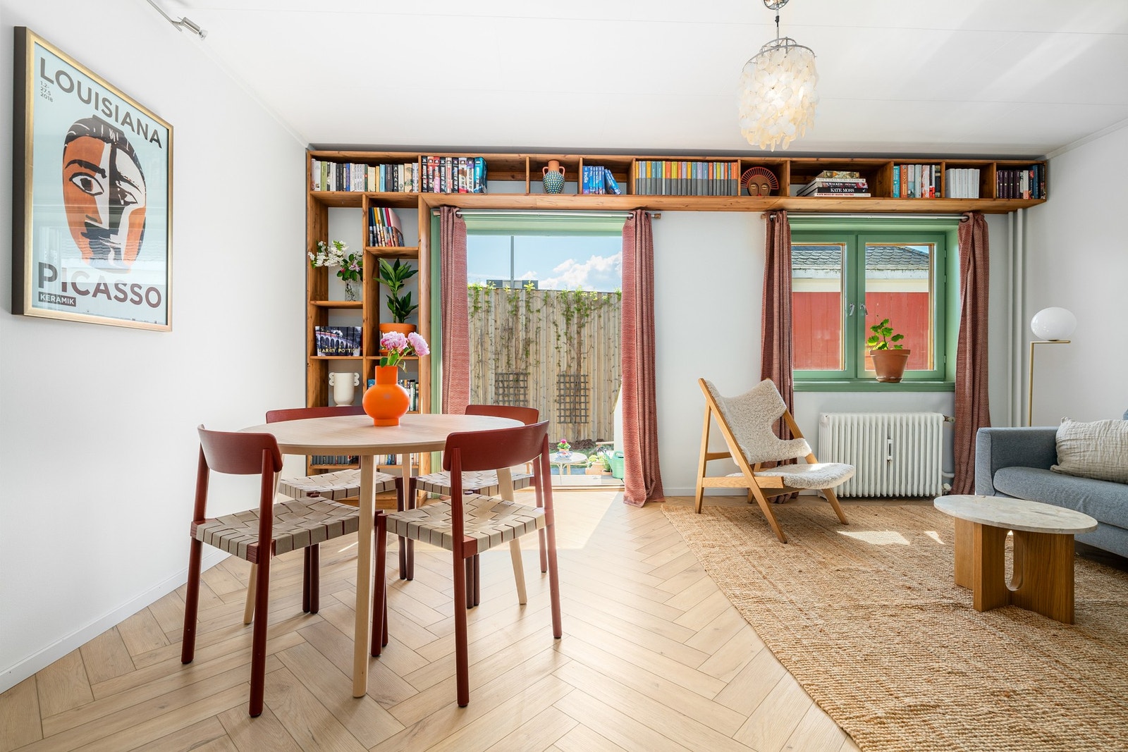 Lys og luftig stue med utgang til balkong, samt plassbygget bokhylle bygget av møbelsnekker i 2022. Galleribilde