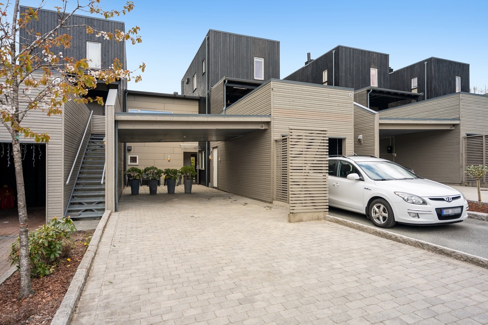 Bilen parkerer du i gårdsrommet, som er opparbeidet med belegningsstein og har plass til flere biler, i tillegg til carport. Galleribilde