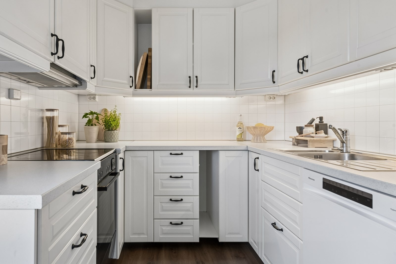 Takhøy hesteskoformet kjøkkeninnredning med profilerte fronter, laminat benkeplate og kitchen wall mellom benk og overskap. Galleribilde