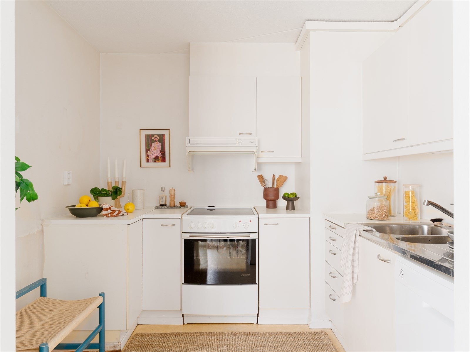 Hvit foliert kjøkkeninnredning med glatte fronter og laminat benkeplate. Komfyr med keramisk topp og oppvaskmaskin er frittstående. Galleribilde
