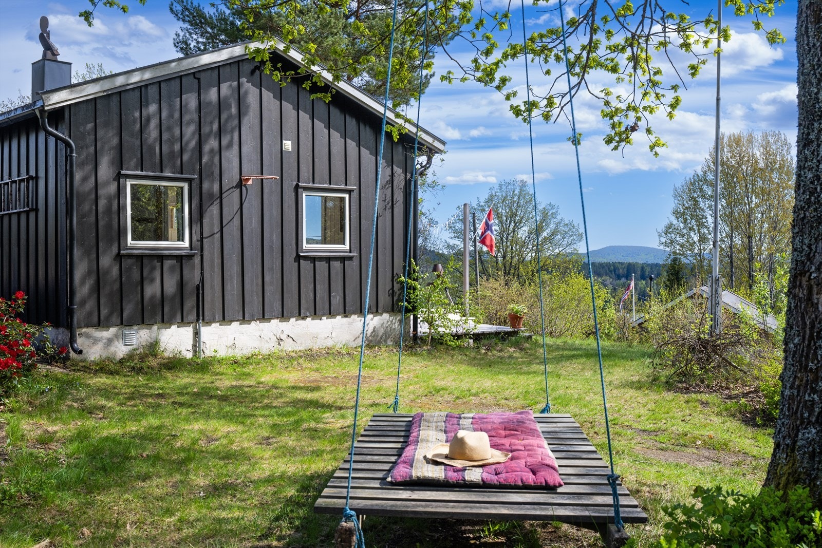 Tomten er en kombinasjon av naturtomt og opparbeidet plen, som gir rom for både lek og avslapning. Galleribilde