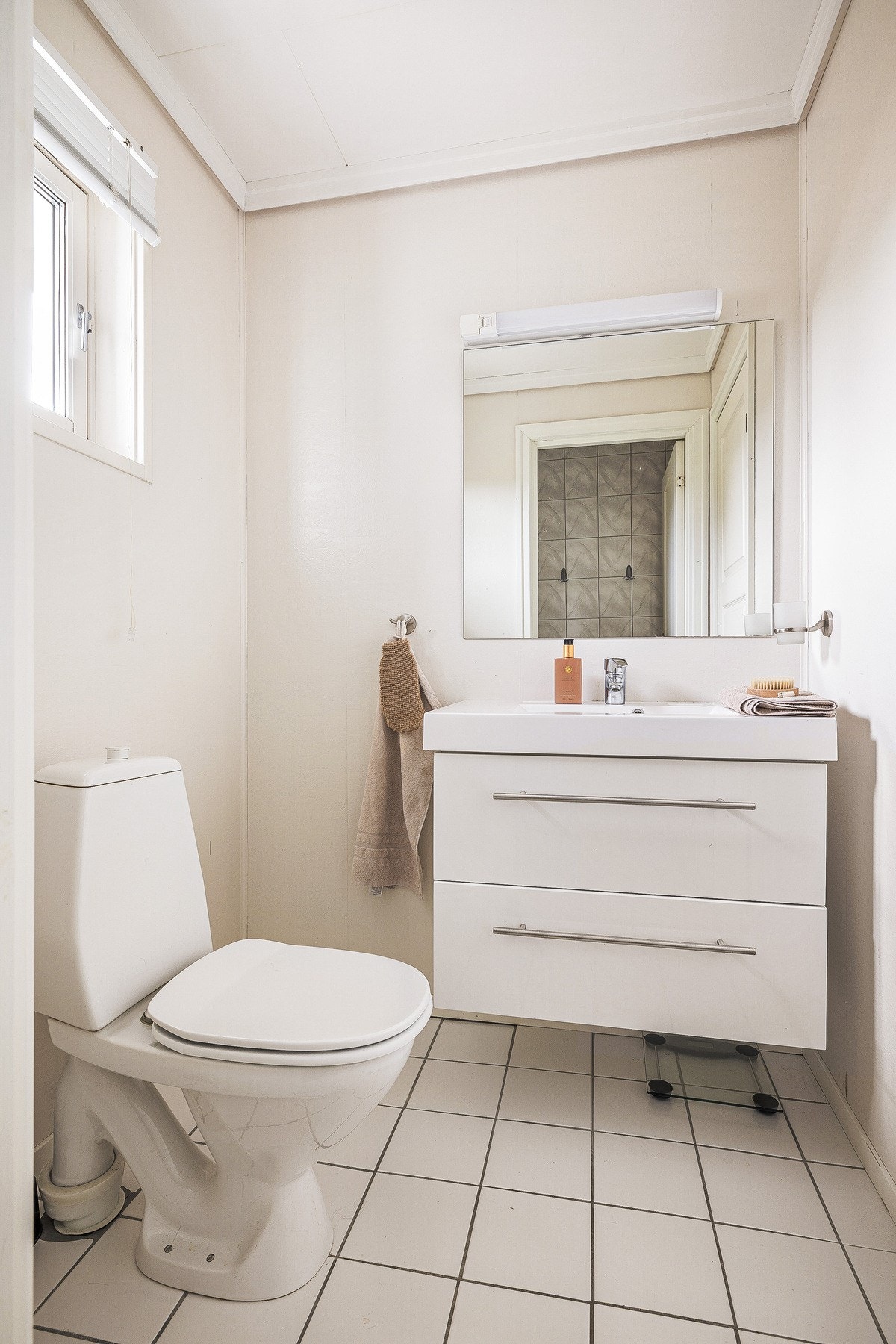 Praktisk og todelt bad med separat dusjdel og toalettdel. Badet er innredet med dusjrom, toalett og skuffeinnredning med servant, og fremstår funksjonelt med en effektiv og smart planløsning. Galleribilde