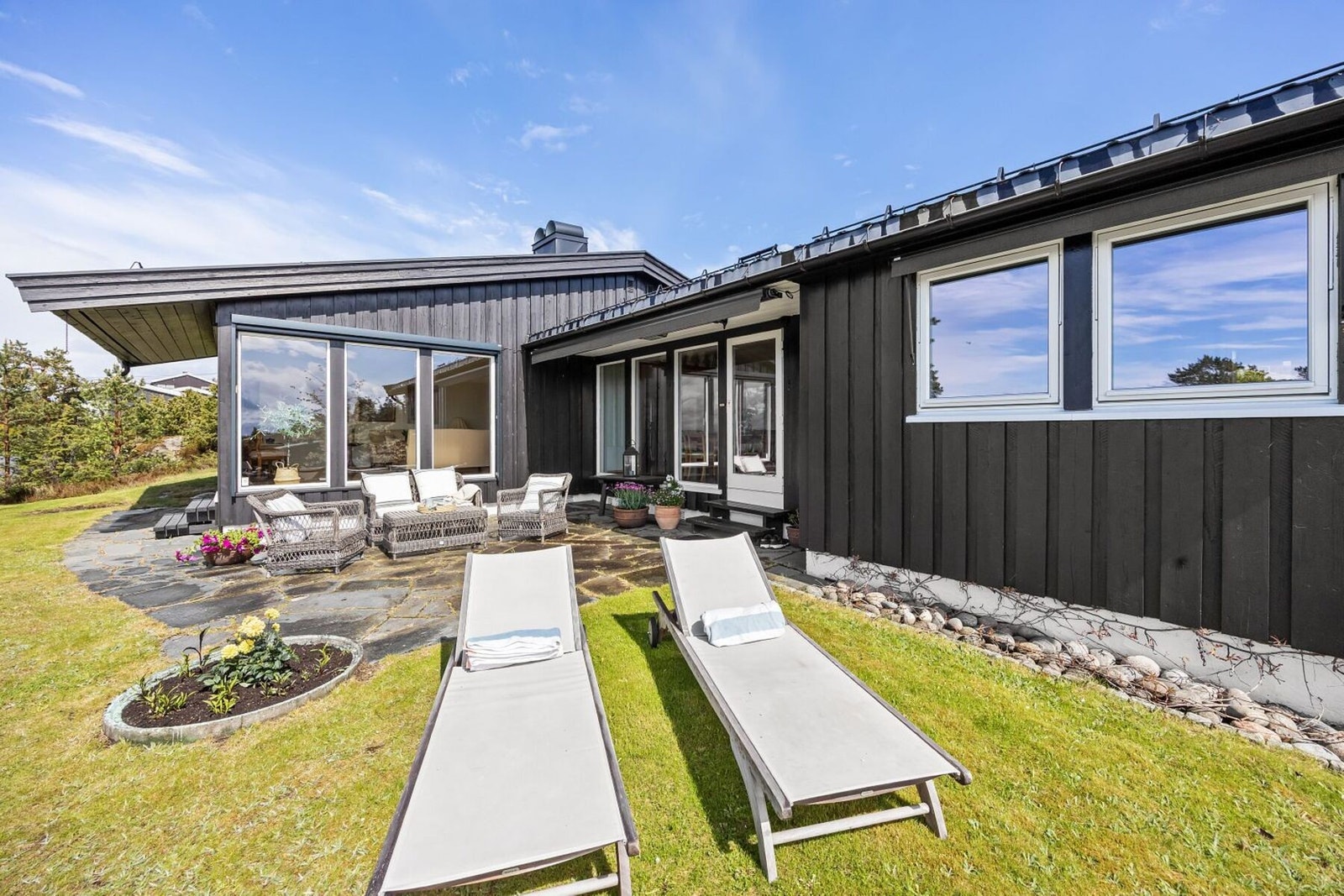 Fra stuen er det direkte utgang til en flott vestvendt skiferlagt terrasse og hagen hvor man kan nyte solen, stillheten og den fantastiske utsikten mot Oslofjorden. Galleribilde