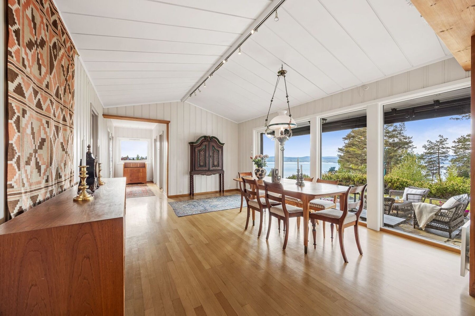 Rommet har store vindusflater som slipper inn rikelig med naturlig lys og samtidig gir vakker utsikt mot hagen og fjorden. Galleribilde