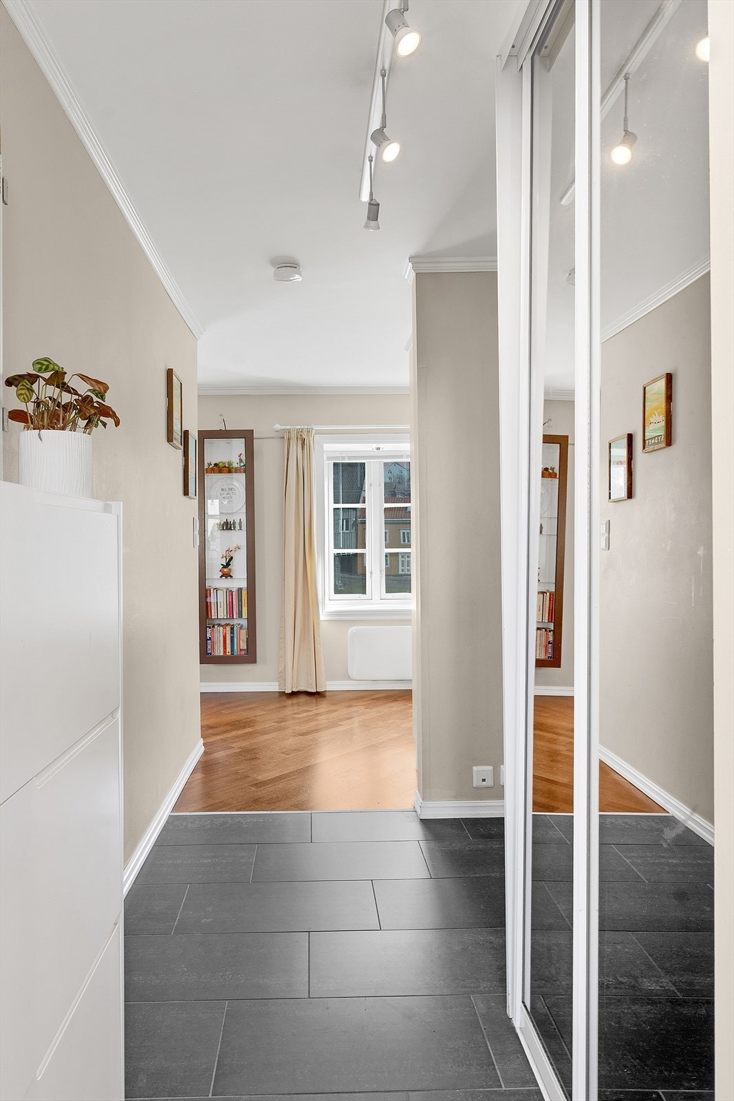 Flislagt inngangsparti med skyvedørsgarderobe. Galleribilde