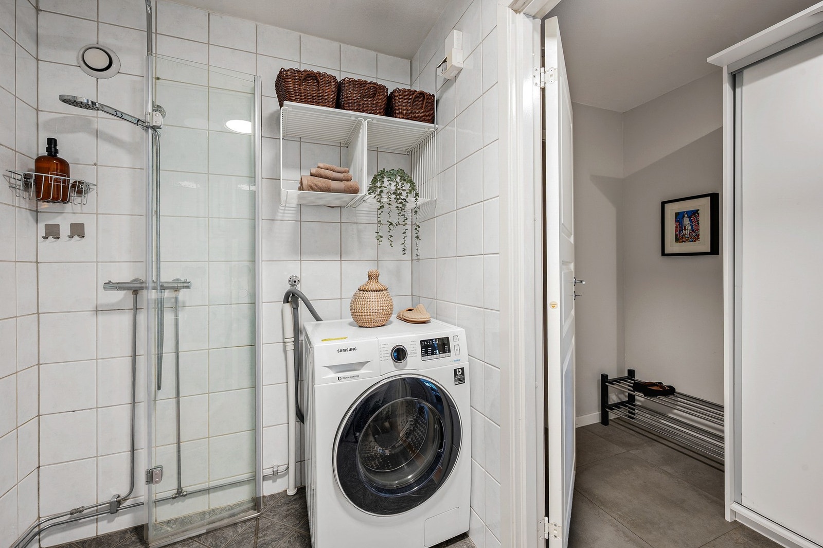 Badet har flislagt gulv med gulvvarme og opplegg for vaskemaskin. Galleribilde