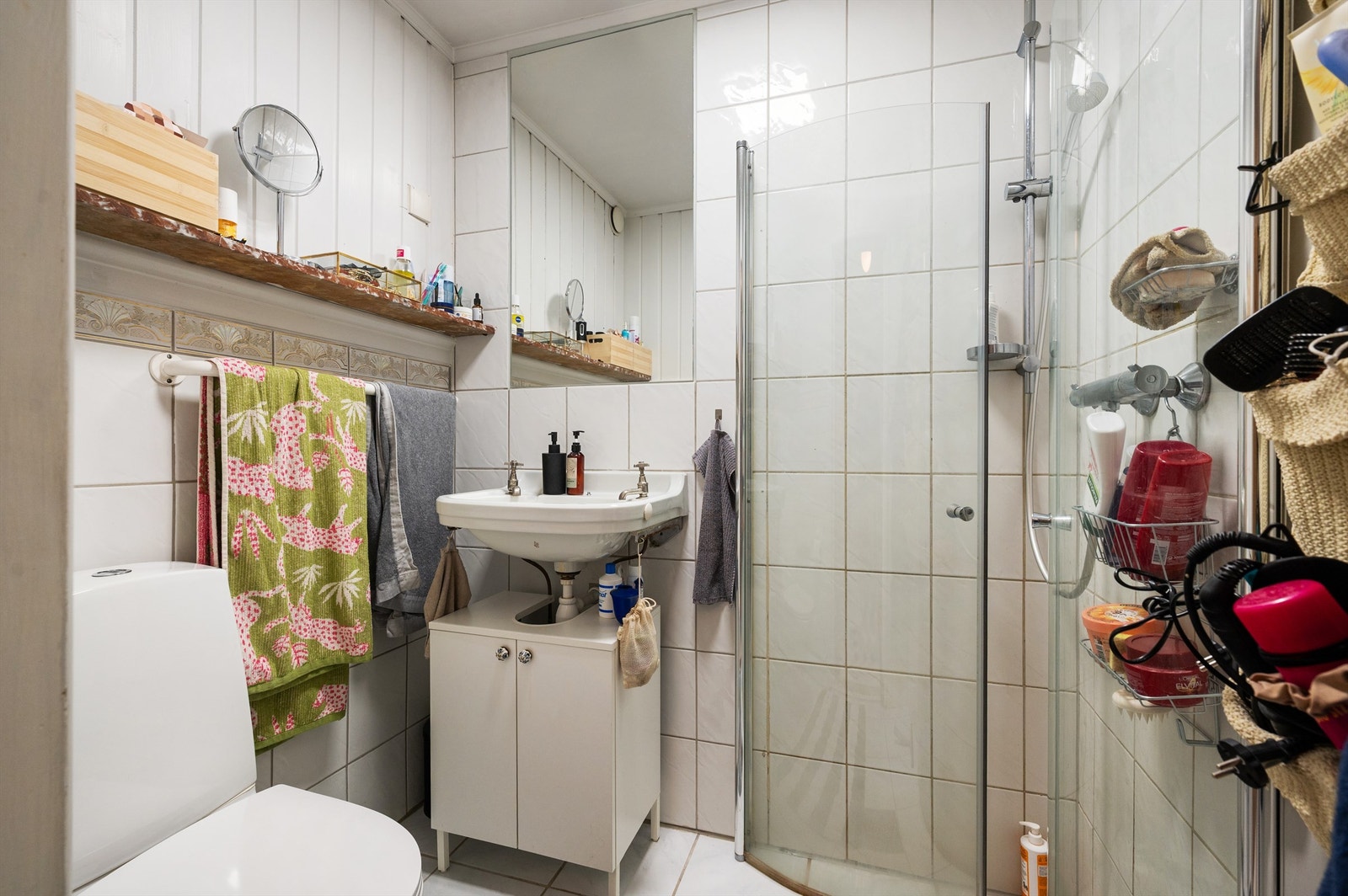 Baderommet er flislagt med varmekabler i gulv og er innredet med frittstående toalett, servant med ovenpåliggende vask og dusjsone med innfellbare dører i glass som er tilkoblet hånddusj. Det er gitt TG3 på badet. Galleribilde