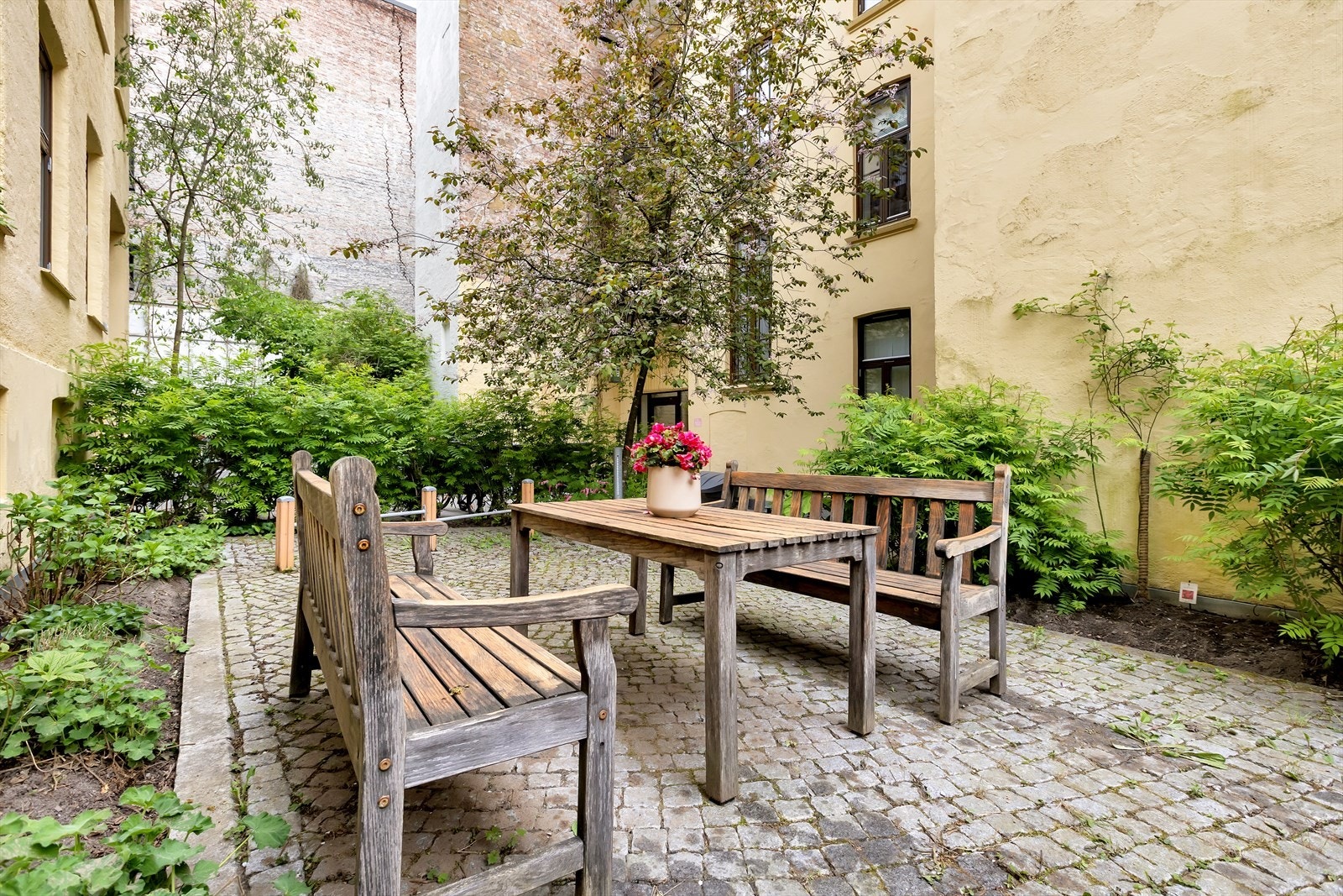 Felles uteområde med brostein og sittegruppe gir et hyggelig samlingspunkt. Galleribilde