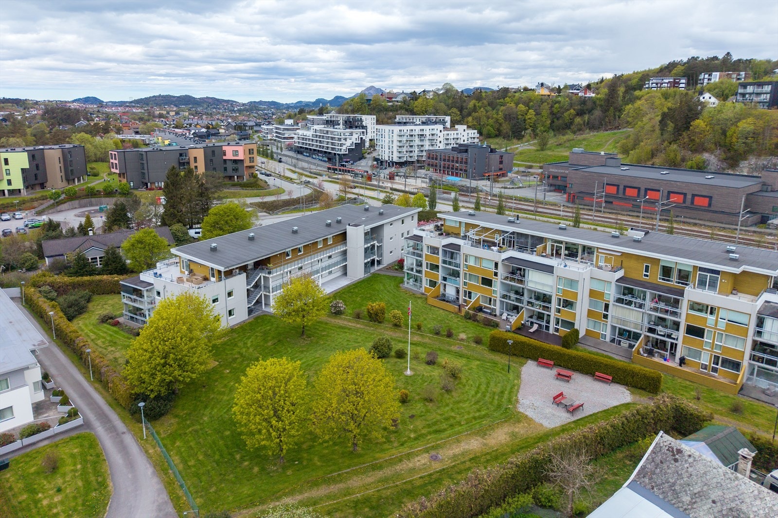Flotte utearelaersom er opparbeidet med plen, bed, trær og benker. Galleribilde