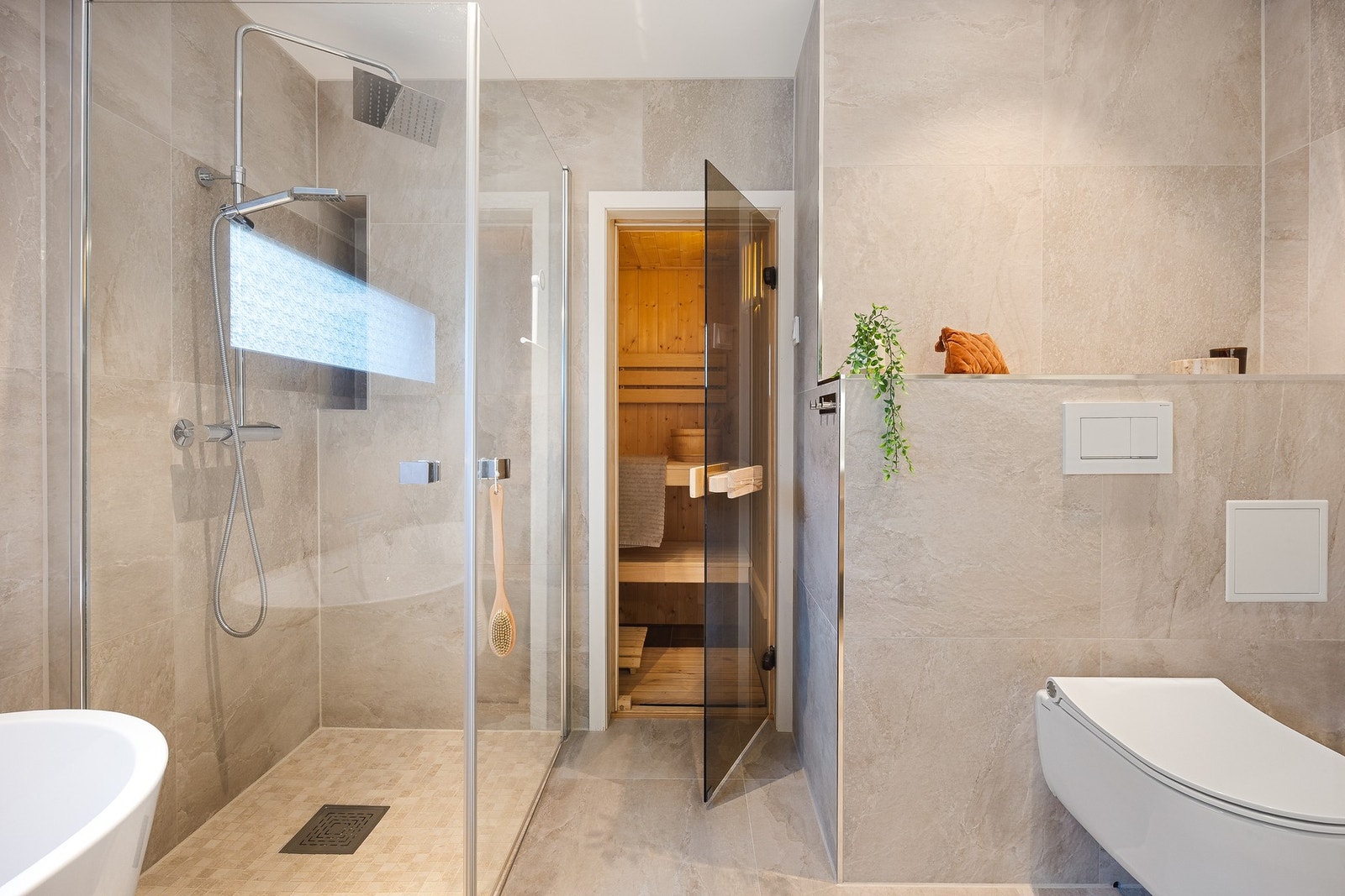 Det flotte og moderne badet er innredet med dusjhørne, vegghengt toalett, badekar, vegghengt dobbel-servant med møblement. Galleribilde