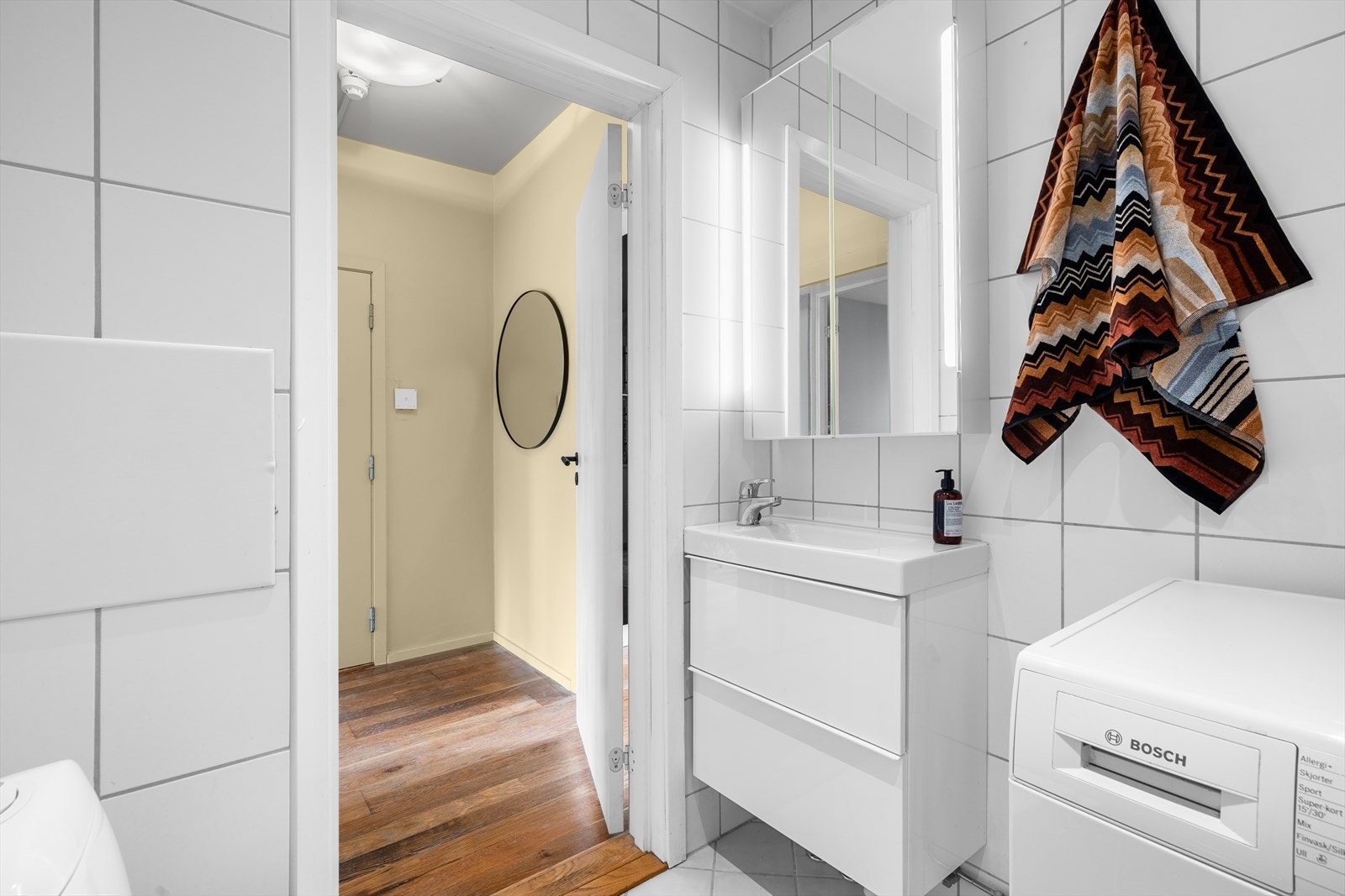 Badet er innredet med klosett, servant nedfelt i baderomsinnredning, speil med belysning samt dusjgarnityr. Galleribilde