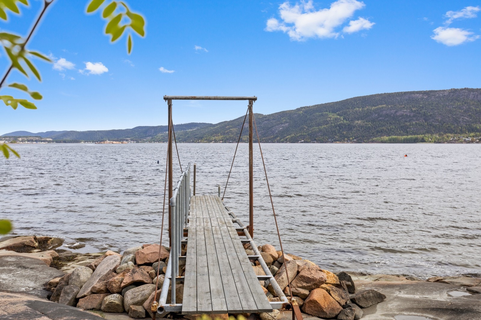 Helt nede ved sjøen finner du et stupebrett med tilhørende badestige, som gir enkel og trygg adkomst til vannet. Her ligger alt til rette for forfriskende morgenbad, barnevennlig lek og late sommerdager ved vannkanten. Galleribilde