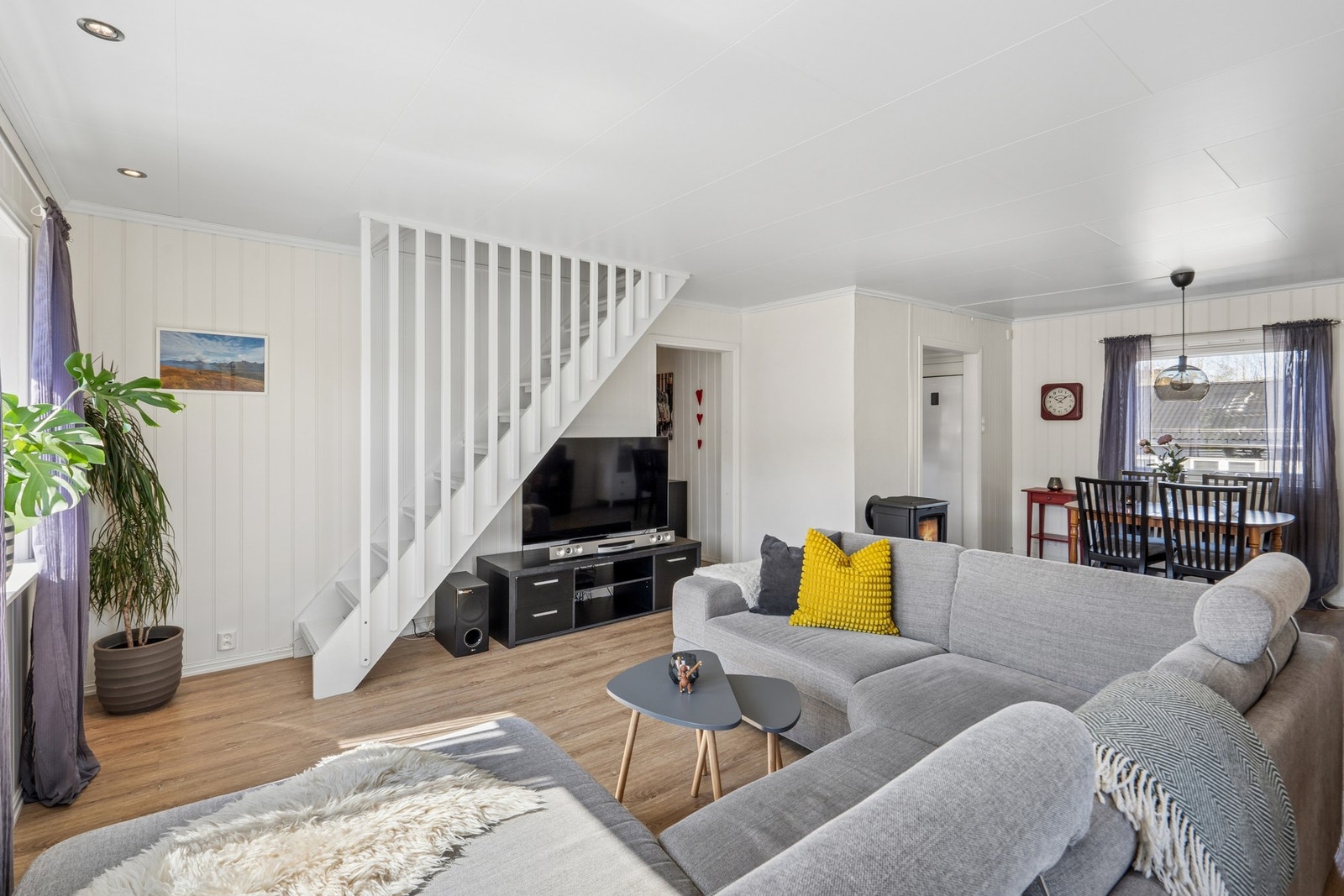 Den malte tretrapper med åpent spilerekkverk leder opp til en hyggelig loftsetasje. Galleribilde