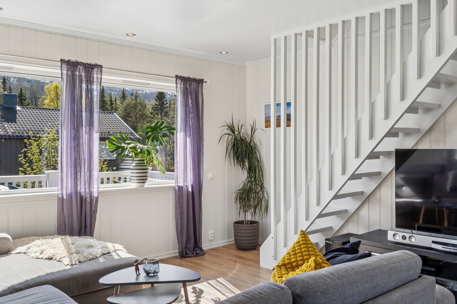 Store vindusflater i stuen gir rikelig med naturlig lys. Galleribilde