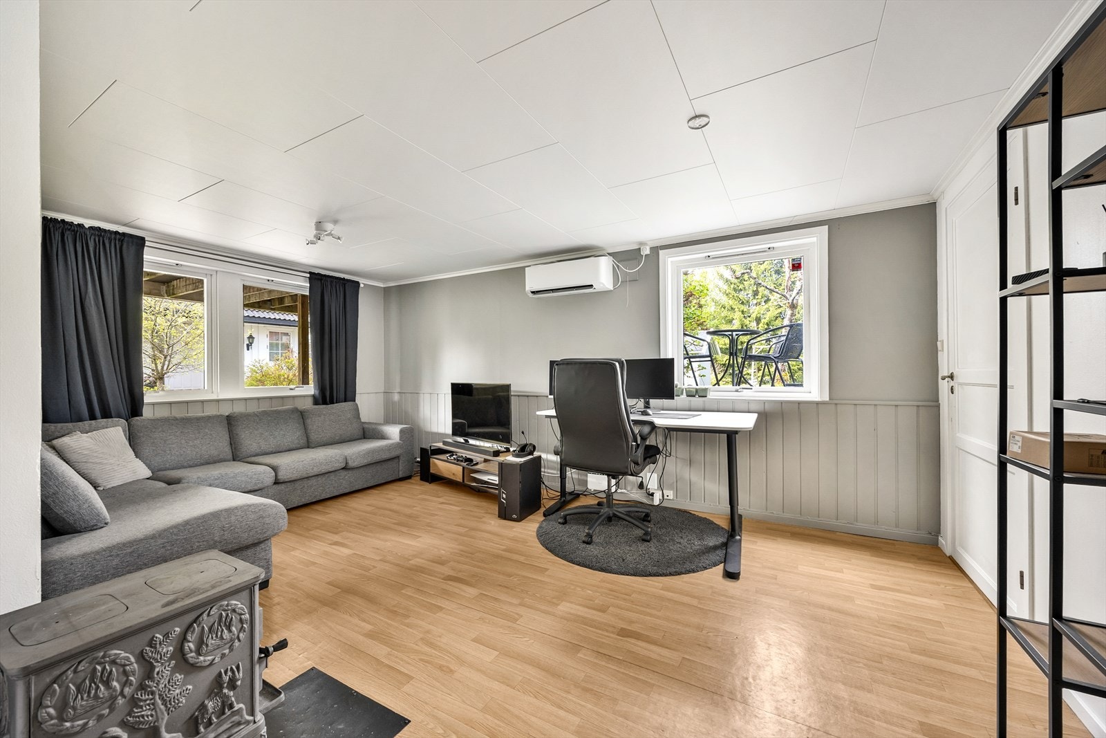 Lys og romslig stue i leiligheten med varmepumpe på vegg. Galleribilde