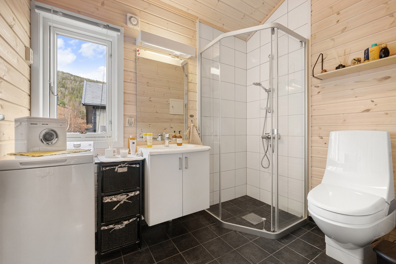 Badet har en praktisk og funksjonell utforming med flislagt gulv med elektriske varmekabler, samt vegger utført i en kombinasjon av fliser og panel som harmonerer godt med hyttas øvrige uttrykk. Galleribilde