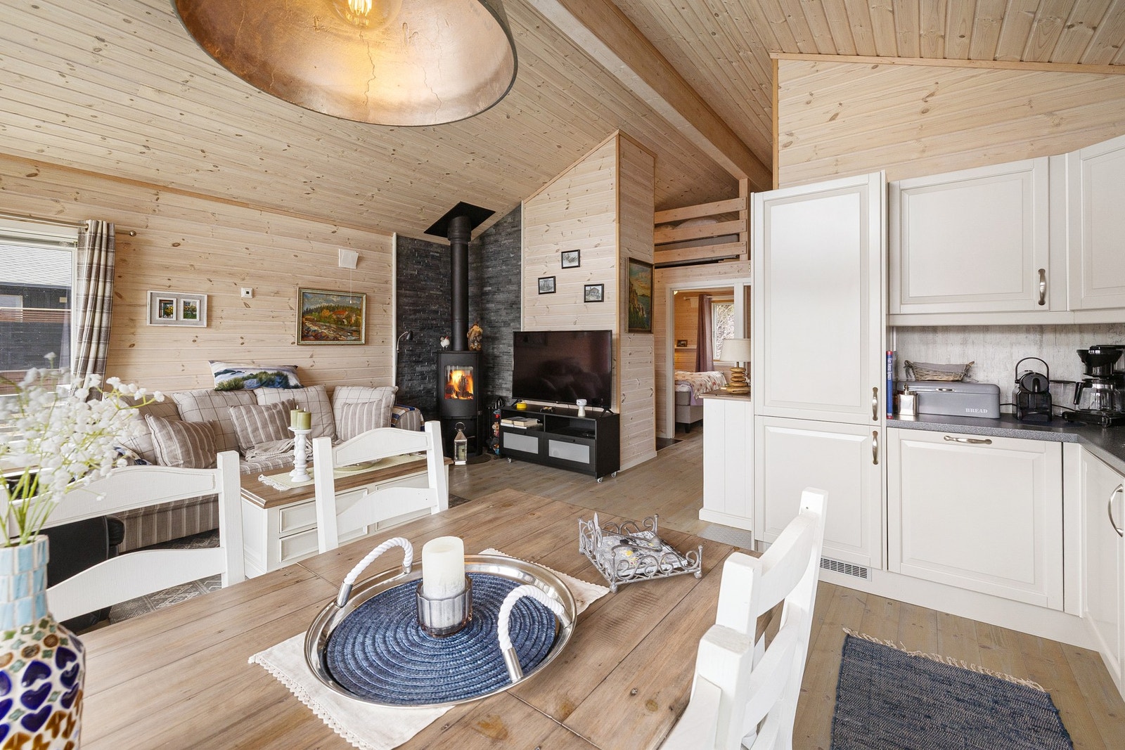Stuen har en åpen og sosial løsning mot kjøkken og spiseplass, med god takhøyde og store vindusflater som slipper inn rikelig med naturlig lys. Galleribilde