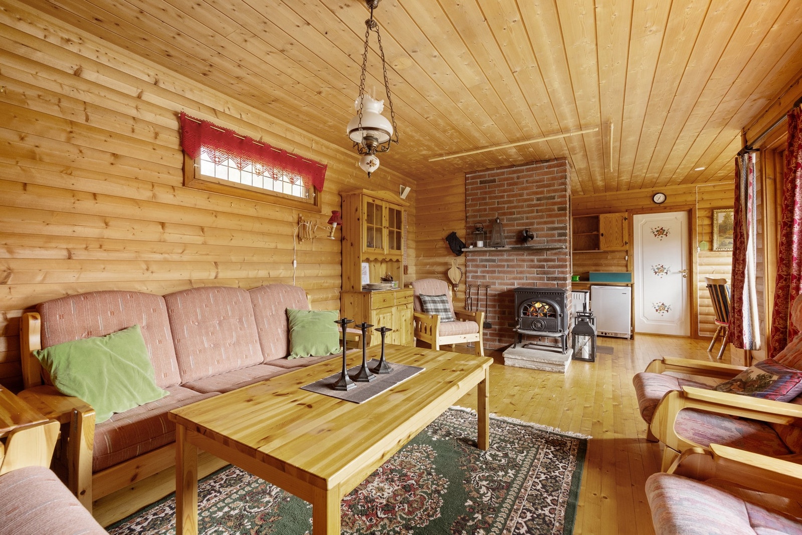 Den hyggelige stuen har plass til både sofa- og spisegruppe, perfekt for rolige kvelder foran vedovnen etter en dag ute i naturen. Galleribilde