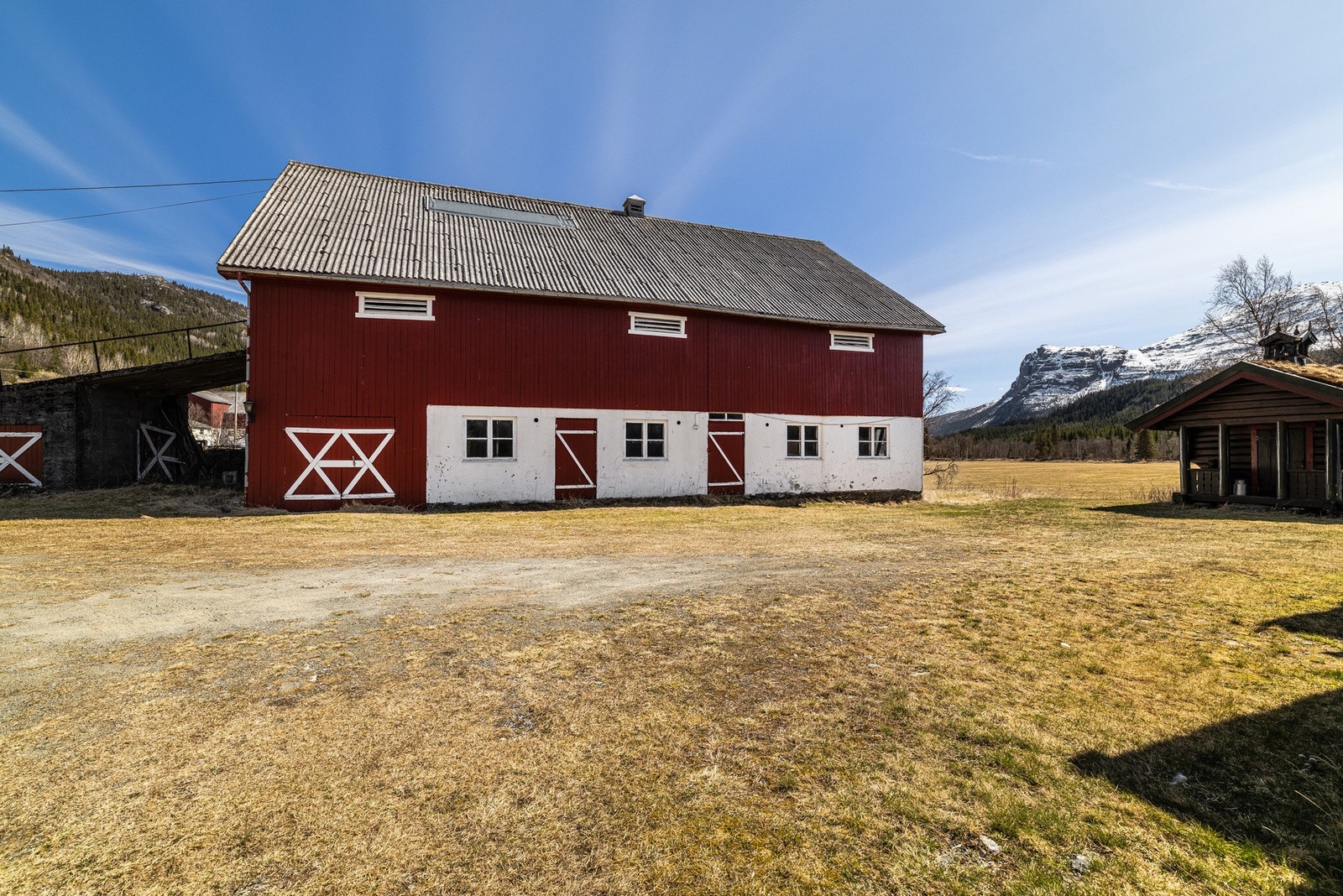 Stor rødbrun låve som byr på rikelig lagringsplass og muligheter for hobbyvirksomhet. Galleribilde